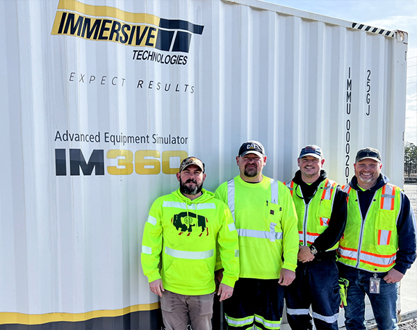 Haile’s training team in front of the IM360 Advanced Equipment Simulator