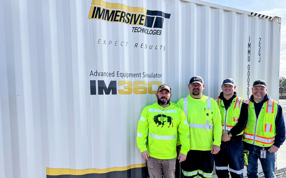Haile’s training team in front of the IM360 Advanced Equipment Simulator